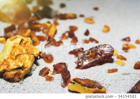 Amber. the pieces of amber in the sand on the Amber. the pieces of amber in the sand on the 34154581