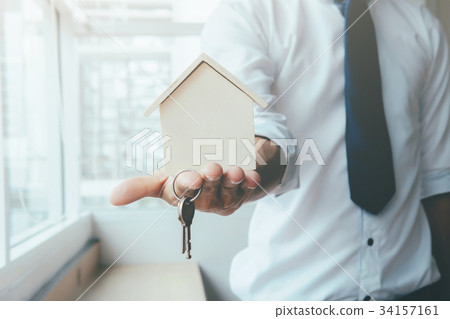 Hand agent with home in palm and key on finger. 34157161