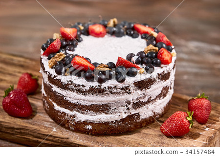 a cut of cake with whipped cream and strawberry 34157484