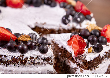 a cut of cake with whipped cream and strawberry 34157487