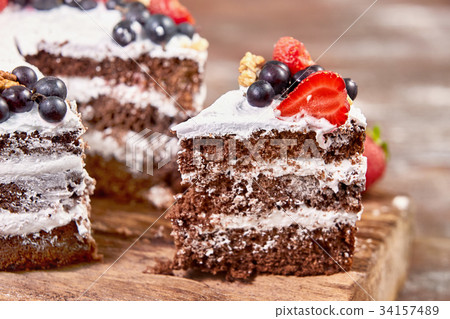 a cut of cake with whipped cream and strawberry 34157489