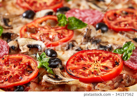 Closeup of pizza with salami, tomatoes and olives 34157562