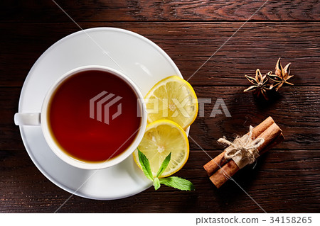 White porcelain cup of tea with cinnamon sticks White porcelain cup of tea with cinnamon sticks 34158265