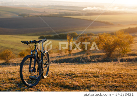 Silhouette of a bike on the hills at sunset. Silhouette of a bike on the hills at sunset. 34158421