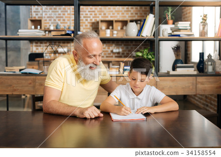Caring grandfather helping his grandson with home Caring grandfather helping his grandson with home 34158554