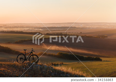Silhouette of a bike on the hills at sunset. Silhouette of a bike on the hills at sunset. 34158863