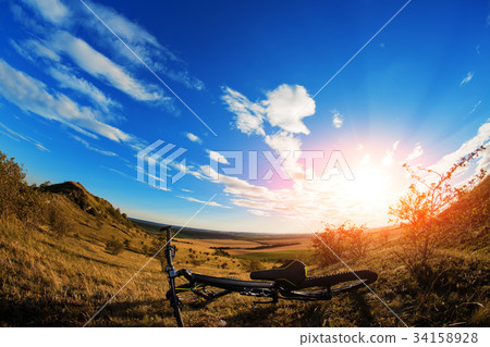 Silhouette of a bike on the hills at sunset. Silhouette of a bike on the hills at sunset. 34158928