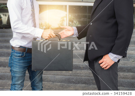Businessman filling black briefcase to exchange transfer deal Businessman filling black briefcase to exchange transfer deal 34159428