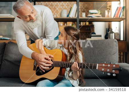 Loving grandfather teaching his granddaughter how Loving grandfather teaching his granddaughter how 34159518