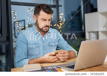 Serious troubled man checking his messages Serious troubled man checking his messages 34160265