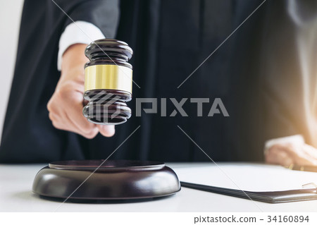 Close up of Male lawyer or judge hand's striking the gavel on so Close up of Male lawyer or judge hand's striking the gavel on so 34160894