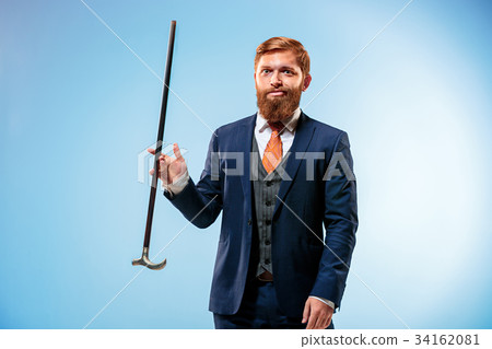 Tattooed bearded man in a suit holding cane. Tattooed bearded man in a suit holding cane. 34162081