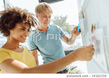 Young international colleagues using sticky notes 34162338