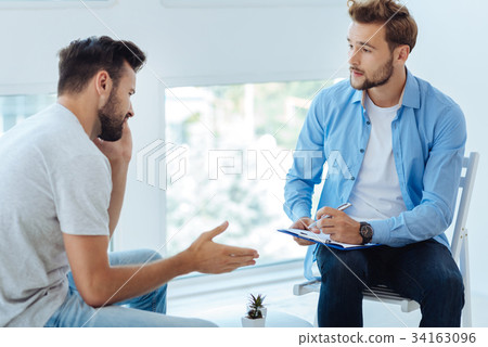 Nice sympathetic doctor listening to his patient Nice sympathetic doctor listening to his patient 34163096
