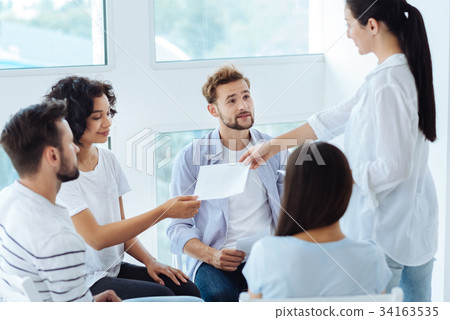 Professional group therapist giving sheets of Professional group therapist giving sheets of 34163535