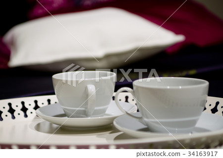 Cups with pillow on a bed Cups with pillow on a bed 34163917