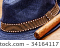 blue hat and cigar on wooden floor, smoke concept 34164117