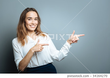 Happy delighted woman pointing to the left 34164270