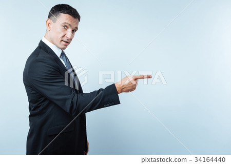 Handsome nice entrepreneur pointing in front of 34164440