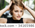 Girl brushing her hair through with fingers. 34165986