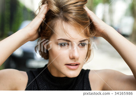 Girl brushing her hair through with fingers. 34165986