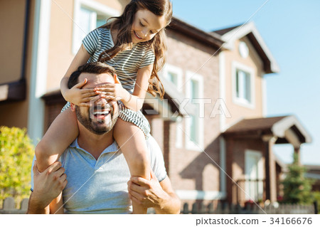 Little girl sitting on fathers shoulders and 34166676
