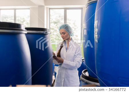 Manufacturing employee writing report during Manufacturing employee writing report during 34166772