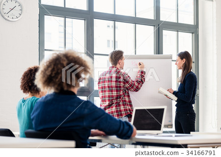Student writing on a training paper board while Student writing on a training paper board while 34166791