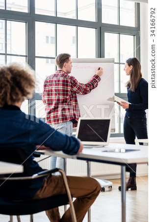 Student writing on a training paper board while Student writing on a training paper board while 34166792