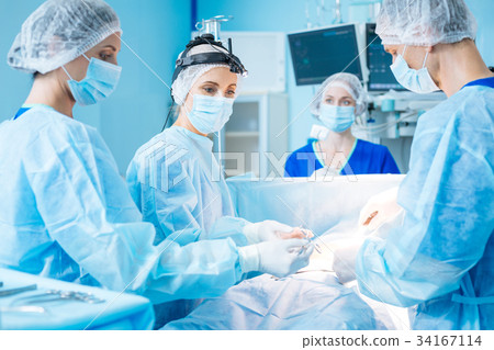 Serious doctor looking at her assistant 34167114