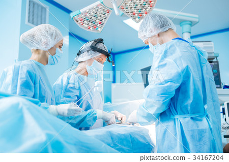 Attentive medical workers operating their patient Attentive medical workers operating their patient 34167204