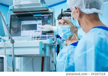 Serious assistant looking at his operation teacher Serious assistant looking at his operation teacher 34167318