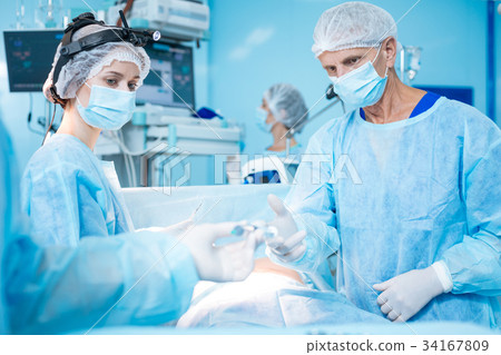 Serious assistant looking at male hands Serious assistant looking at male hands 34167809