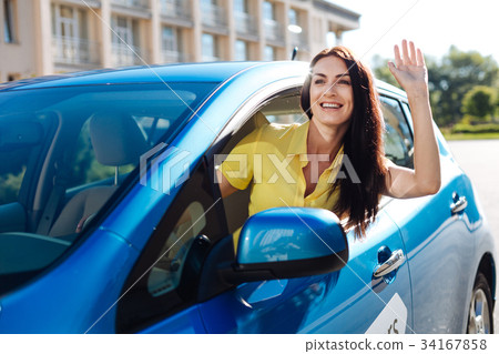 Joyful positive woman greeting her friend Joyful positive woman greeting her friend 34167858