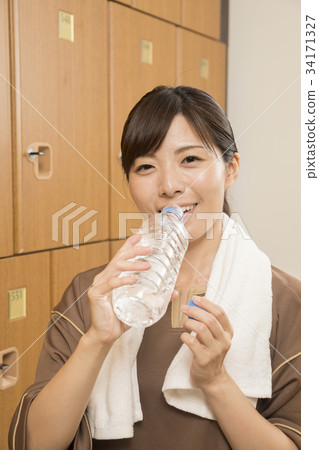 Woman doing hydration in the changing room of the spa facility 34171327