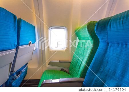 Airplane seat near windows in cabin of aircraft Airplane seat near windows in cabin of aircraft 34174504