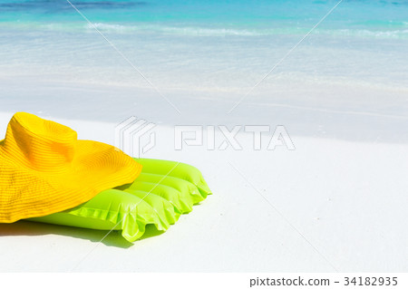 Green airbed ans hat on beach Green airbed ans hat on beach 34182935