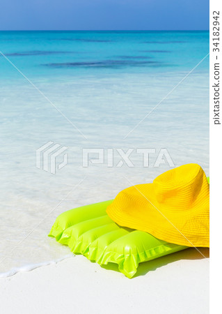 Green airbed ans hat on beach Green airbed ans hat on beach 34182942