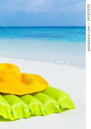 Green airbed ans hat on beach 34182950