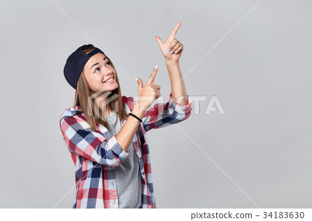 Teen girl pointing up at empty copy space Teen girl pointing up at empty copy space 34183630