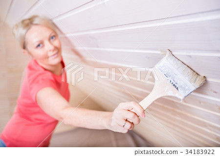 Woman painting wooden boards in white color Woman painting wooden boards in white color 34183922