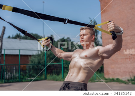 Male athlete close-up, trains nature city, summer 34185142