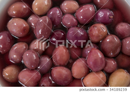 Close-up marinated olives with glasses of wine and cheese in tray 34189239