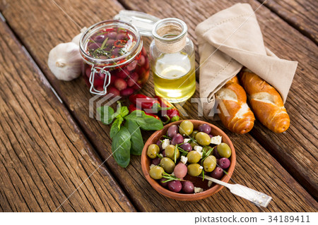 Close up of brown olives with herb in ladle Close up of brown olives with herb in ladle 34189411