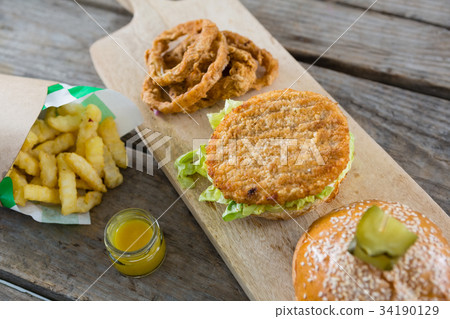 Chili peppers and burger on chopping board 34190129