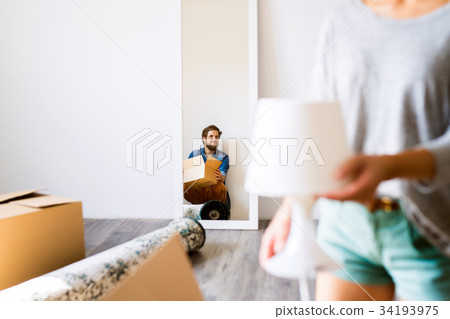 Young couple moving in new house, cardboard boxes. 34193975