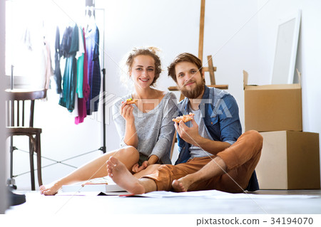 Young couple sitting on the floor moving in new 34194070