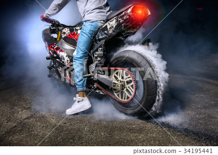 圖庫照片: moto rider making a stunt on his motorbike