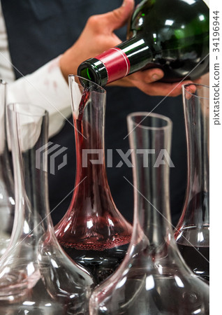 Sommelier at work, pouring wine to decanter while 34196944