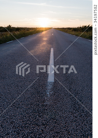 Sunlit asphalt road from low perspective 34197582